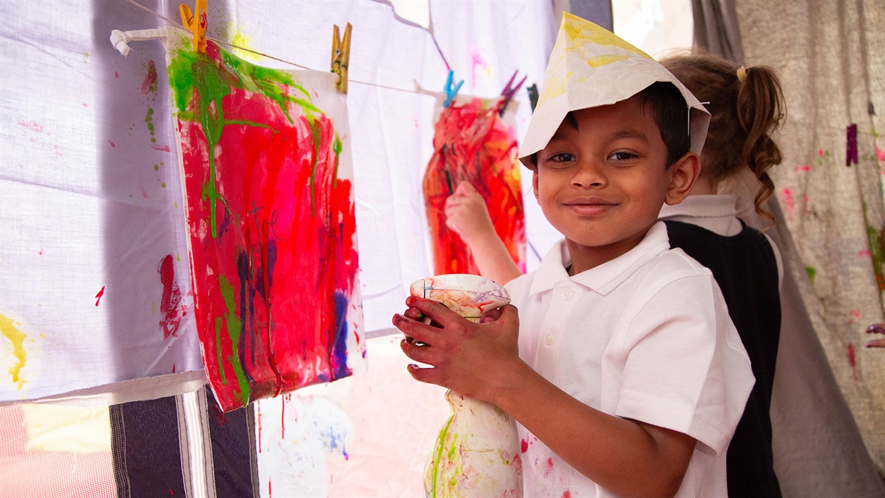 Primary school child enjoying painting activity with Hay Festival