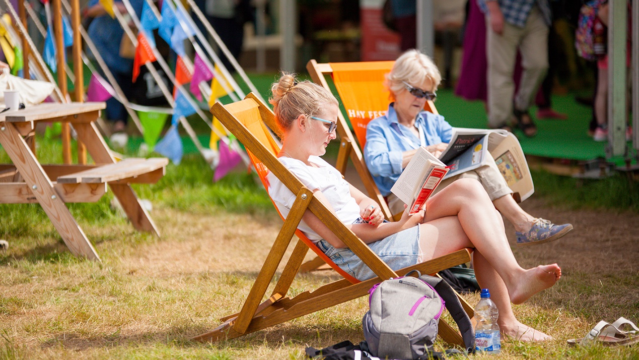 Mother and daughter reading in deckchairs