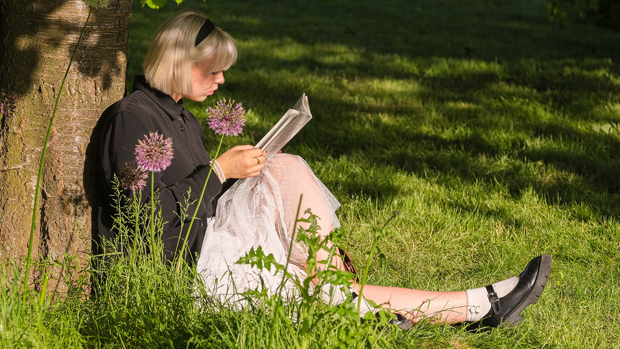 Woman reading a book beneath a tree