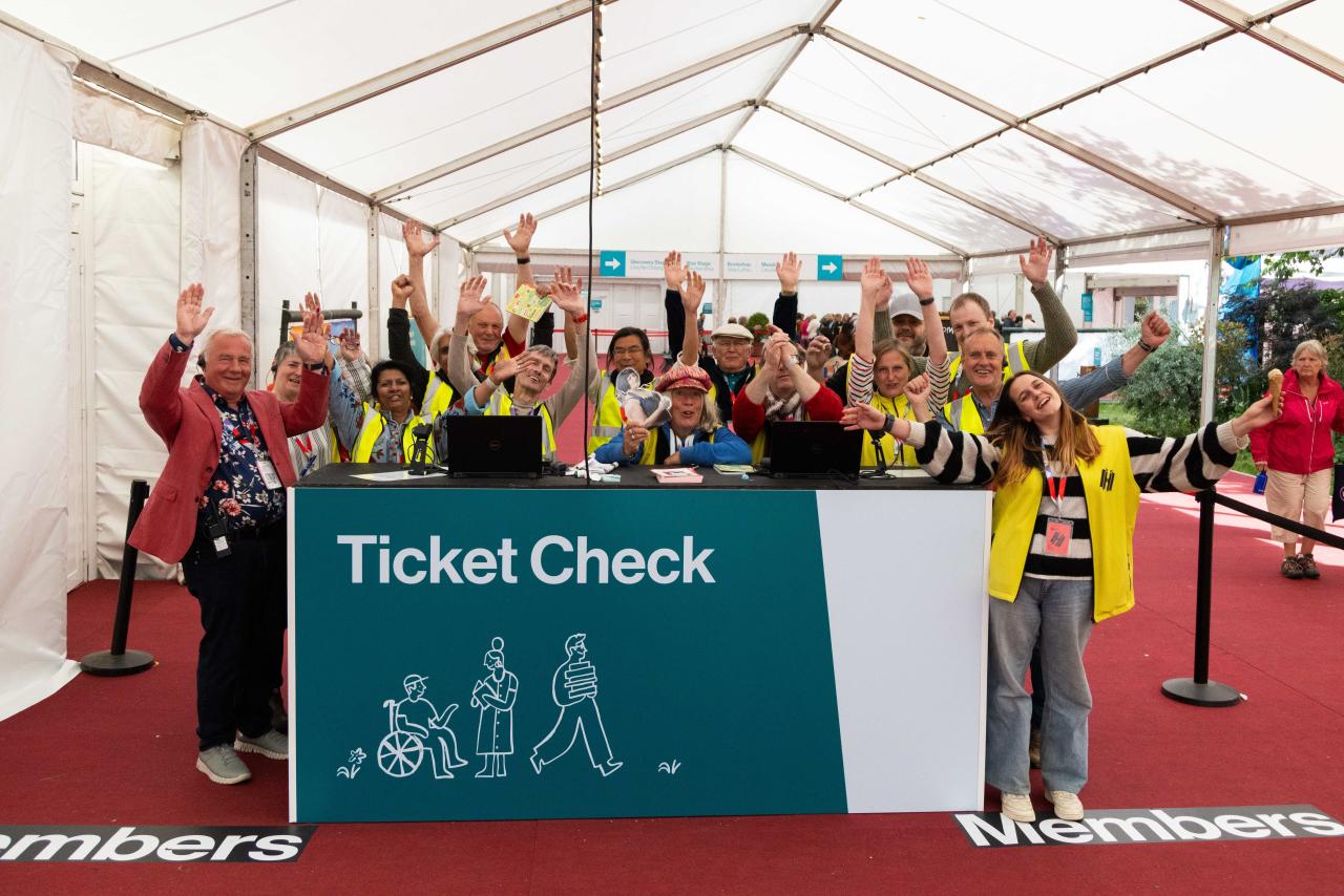 A group of Hay Festival stewards at the ticket check desk waving towards the camera