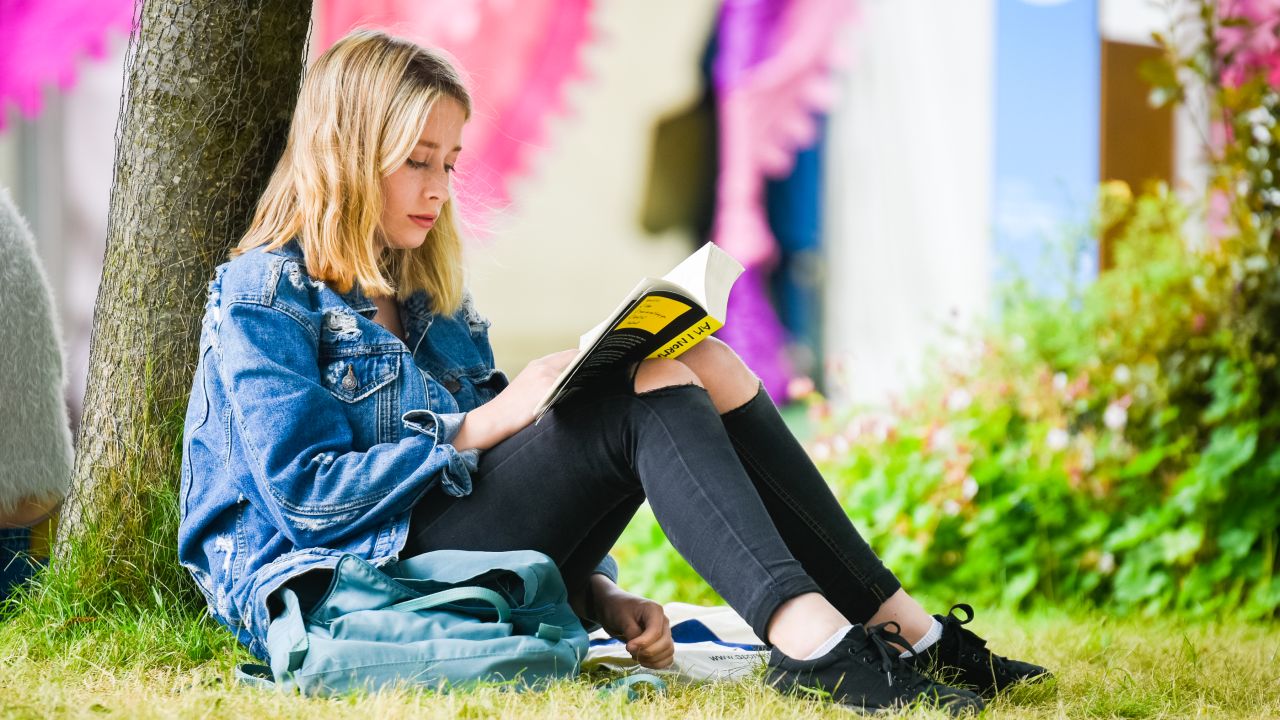 Girl reading under tree at Hay